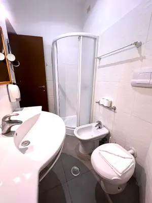 a bathroom with a toilet and a sink and a shower at Booking Inn Settembre 95 in Rome