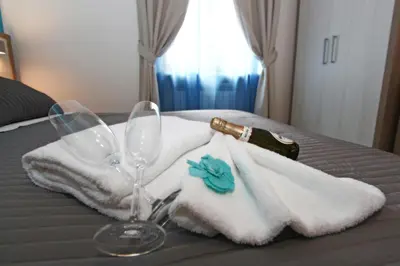 a table with towels and a bottle and a wine glass at La Casa Felice a San Pietro in Rome