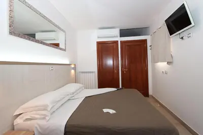 a bedroom with a bed and a tv on the wall at La Casa Felice a San Pietro in Rome