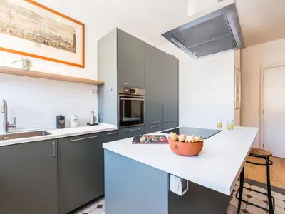 a kitchen with gray cabinets and a bowl of fruit on a counter at The Best Rent - Apartment in Trastevere area in Rome