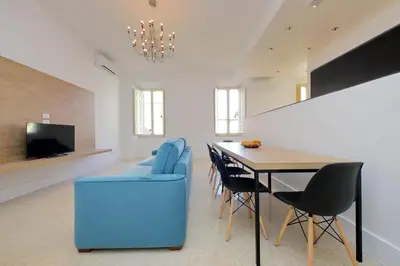 a dining room with a blue chair and a table at Youroom Quattro Fontane Appartamento in Rome