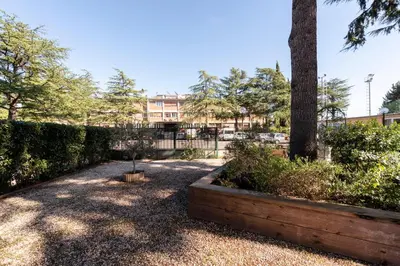a garden with trees and a building in the background at Casa per Ferie Opera Don Calabria in Rome