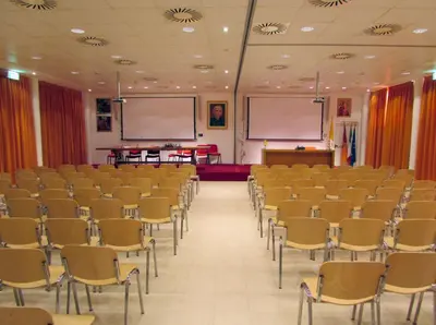 an empty lecture hall with chairs and a podium at Casa per Ferie Opera Don Calabria in Rome