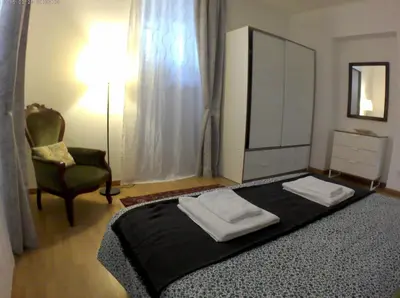 a bedroom with a bed with a dresser and a chair at LILIUM HOUSE Apts in Rome