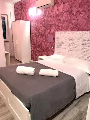 a bedroom with a large bed with two towels on it at NASONI DI ROMA (VICINISSIMO BASILICA SAN GIOVANNI IN LATERANO) in Rome