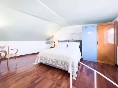 a bedroom with a white bed and a chair at Casa Triunfo Boutique Apartment in Rome