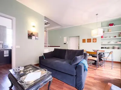 a living room with a blue couch and a table at Casa Triunfo Boutique Apartment in Rome