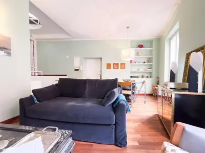 a living room with a blue couch and a kitchen at Casa Triunfo Boutique Apartment in Rome