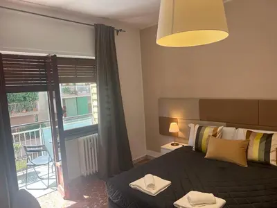 a bedroom with a bed and a balcony with a view at IN ROMA LIFE in Rome