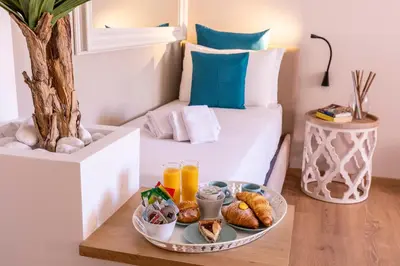 a room with a bed with a tray of food on a table at Trastevere Paper Suites in Rome