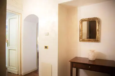a hallway with a mirror and a wooden table at La dolce Silla - Appartamenti al Vaticano,Via Silla 91 in Rome
