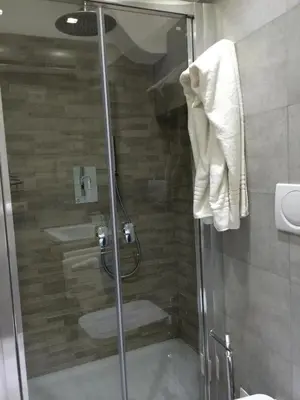 a shower with a glass door in a bathroom at Savelli Apartment Old Town - near Navona Place in Rome