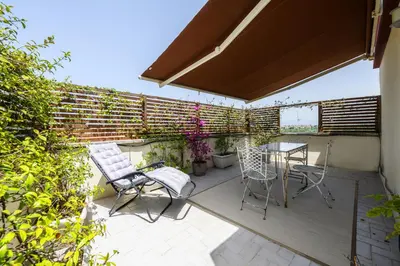a patio with chairs and a table on a deck at Rooftop Porretta Città Giardino Check-in From 3 Pm To 10 Pm in Rome