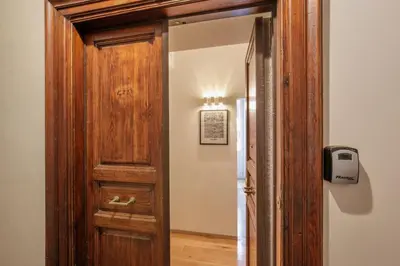 an open wooden door with a light on the wall at Porta Castello Charme in Rome