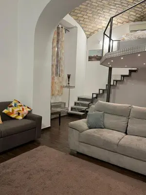 a living room with a couch and a staircase at la rosa di roma colosseo in Rome