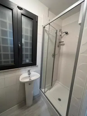 a bathroom with a glass shower and a sink at la rosa di roma colosseo in Rome