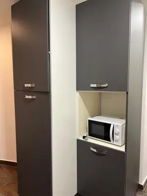 a small kitchen with a microwave on a shelf at la rosa di roma colosseo in Rome