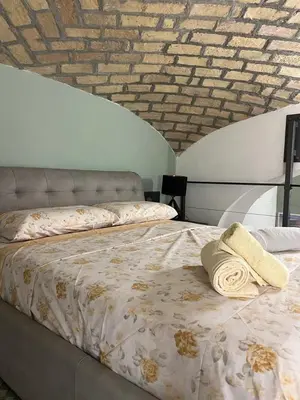 a bed in a room with a brick wall at la rosa di roma colosseo in Rome