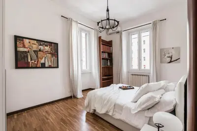 a white bedroom with a bed and a book shelf at The Best Rent - Three-bedroom apartment in Porta Maggiore area in Rome