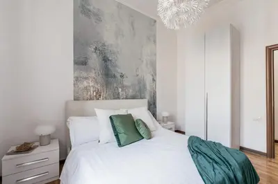 a bedroom with a white bed with two green pillows at The Best Rent - Three-bedroom apartment in Porta Maggiore area in Rome