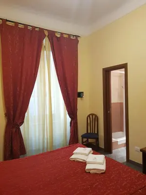 a bedroom with a red bed with towels on it at B&B Rudy Center in Rome