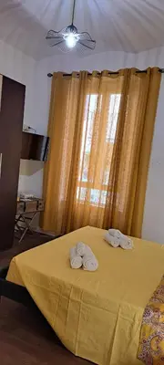 a bedroom with a yellow bed with two towels on it at Central Rome Suite in Rome