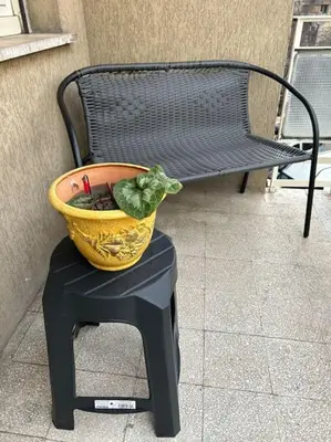 a flower pot sitting on a stool next to a bench at Pochi passi da San Pietro Metro A Cipro in Rome