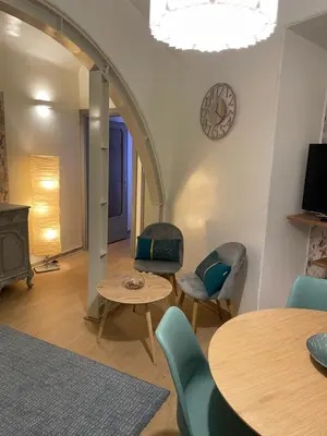a living room with tables and chairs and a clock at Blue vatican house Rome in Rome