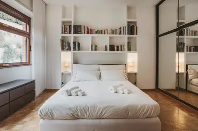 a bedroom with a large white bed with bookshelves at EasyTopStay - Peaceful Retreat near San Pietro in Rome
