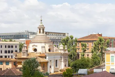 a white building with a cross on top of it at Colosseo Modern by Rental in Rome in Rome