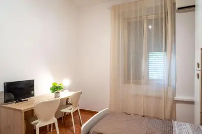 a bedroom with a desk and a bed and a television at La Maison D'Amelia in Rome