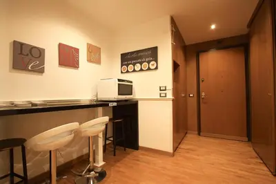a bar with stools and a microwave on a counter at Giulio Cesare Holiday House in Rome
