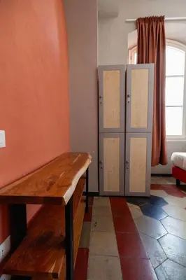 a room with lockers and a wooden bench in a room at Borgo Ripa Urban Travel in Rome