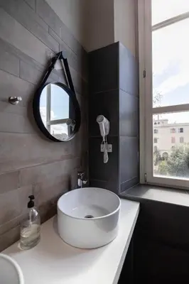a bathroom with a large white sink and a mirror at Borgo Ripa Urban Travel in Rome