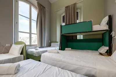 a room with three beds and a mirror at Borgo Ripa Urban Travel in Rome