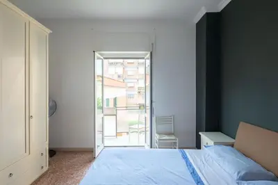 a bedroom with a bed and a large window at Nel cuore di Monteverde in Rome