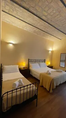 a bedroom with two beds and two lamps and a ceiling at Holiday Suite Roma in Rome