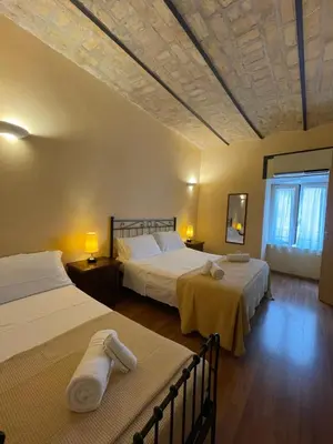 a hotel room with two beds and a ceiling at Holiday Suite Roma in Rome