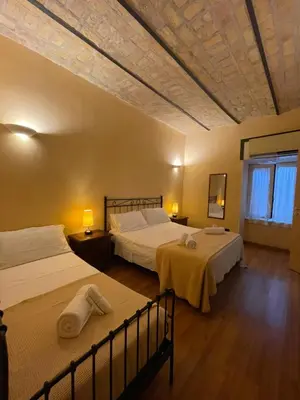 a hotel room with two beds and a window at Holiday Suite Roma in Rome