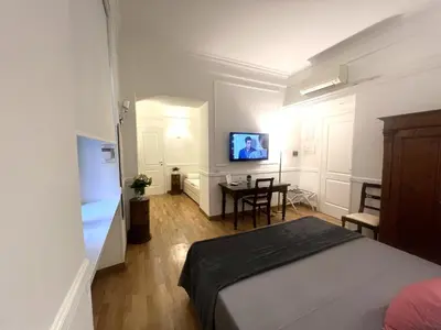a bedroom with a bed and a table and a tv at INTERNO ROMA in Rome