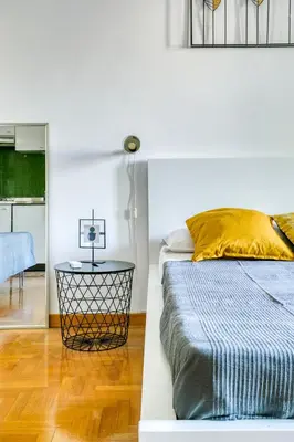 a bedroom with a bed and a table and a mirror at Bright Apartment near Vatican City by RHR in Rome