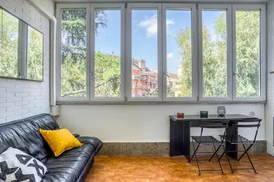 a living room with a leather couch and a table at Bright Apartment near Vatican City by RHR in Rome