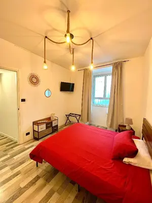 a bedroom with a large red bed and a window at La casa dell’Appio in Rome