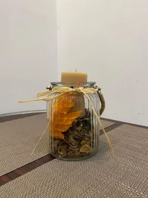 a glass jar filled with rocks and a candle at La casa dell’Appio in Rome