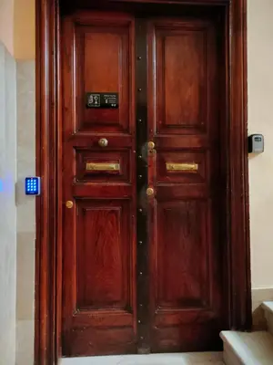 a wooden door in a building with a sign on it at BePlace Holy See in Rome
