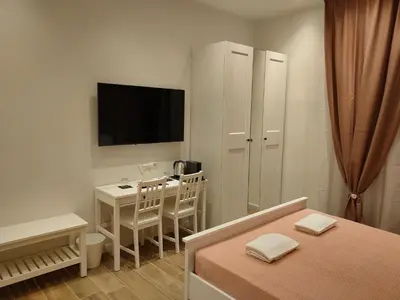a bedroom with a bed and a desk and a television at BePlace Holy See in Rome