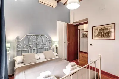 a bedroom with a bed with a blue headboard at MyRHome - Spanish Steps in Rome