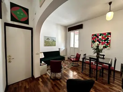 a living room with a green couch and a table at Giglio Penthouse and Terrace in Rome