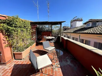 a patio with two chairs and a table on a balcony at Giglio Penthouse and Terrace in Rome