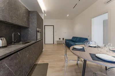 a kitchen and dining room with a table and a couch at Vatican Suite Apartament Roma in Rome